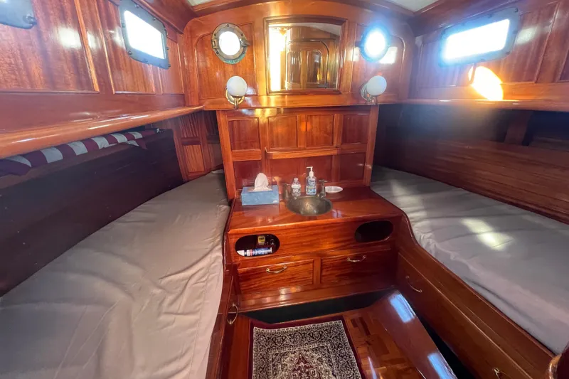 Slide: The Image of Cozy 1966 Moody Salar Motorsailer cabin with rich wood interior and twin berths. - 21