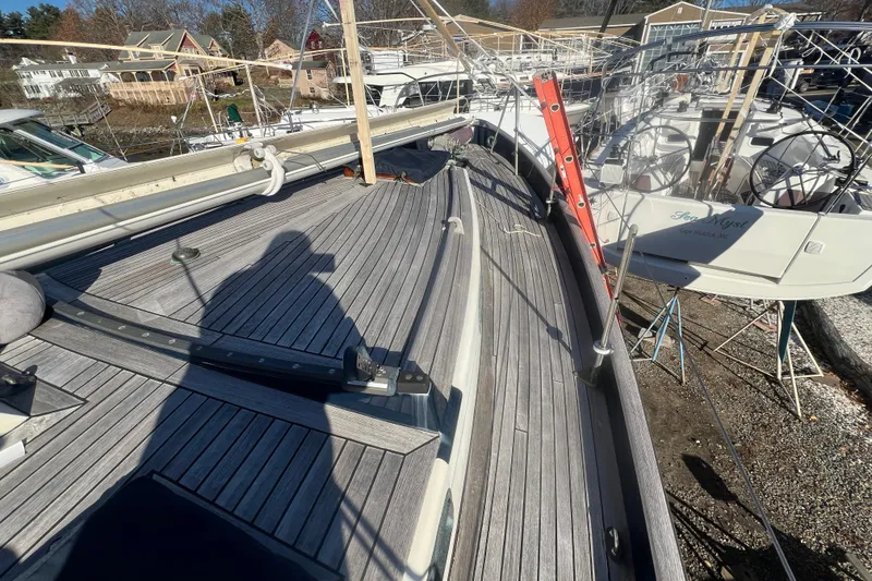 Slide: The Image of 1966 Moody Cutter sailboat deck with shadow and docked boats in background. - 32