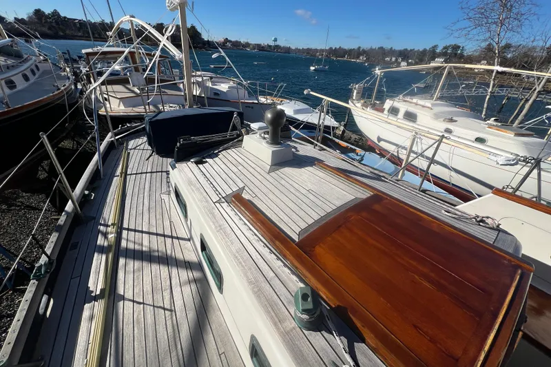 Slide: The Image of 1966 Moody Cutter sailboat docked in a marina, surrounded by other boats. - 34