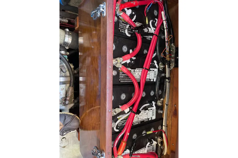 Slide: The Image of Battery compartment of a 1966 Moody Salar Motorsailer with red cables and wooden paneling. - 42