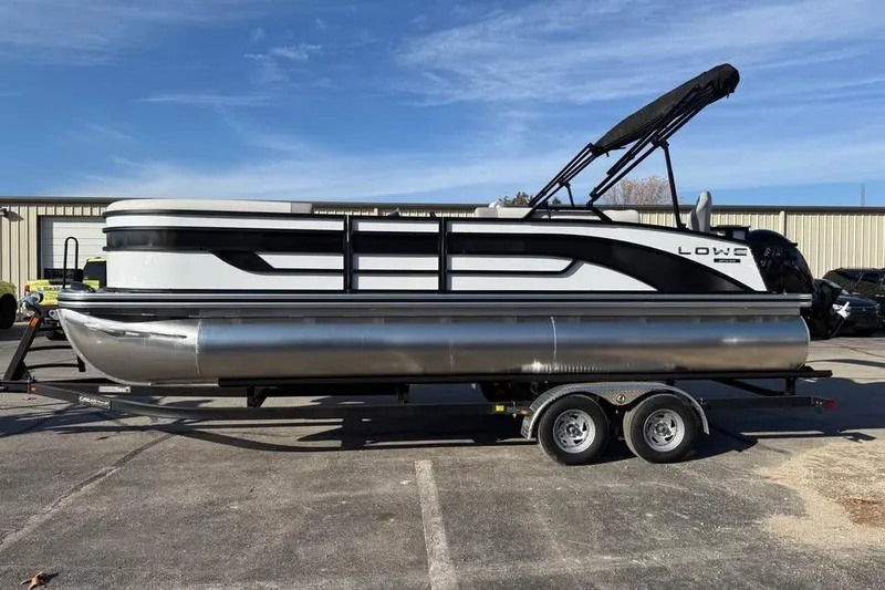 The Image of 2026 Lowe SF 232 Sport Fish pontoon boat on trailer, parked outdoors. - 0