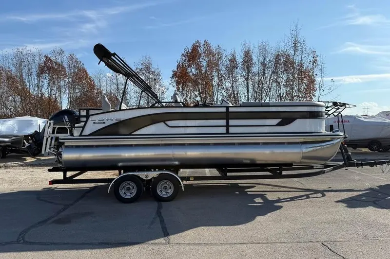 Slide: The Image of 2026 Lowe SF 232 Sport Fish pontoon boat on trailer, parked outdoors. - 4