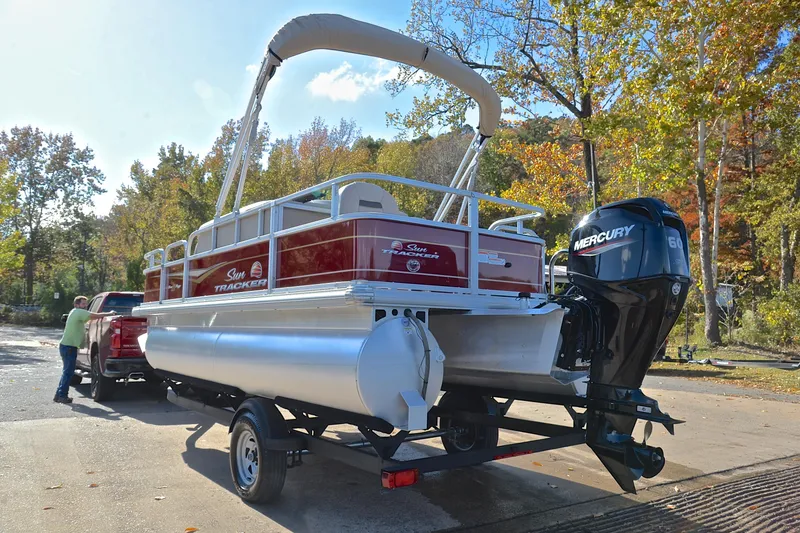 Slide: The Image of 2023 Sun Tracker Bass Buggy 18 DLX pontoon boat on trailer, with Mercury outboard motor. - 12