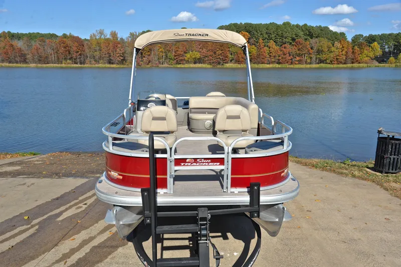 Slide: The Image of 2023 Sun Tracker Bass Buggy 18 DLX pontoon boat by a scenic lake. - 17