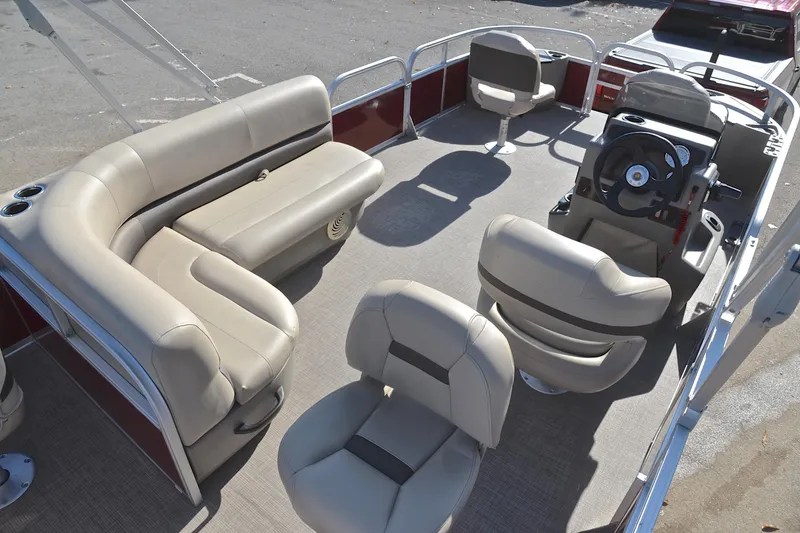 Slide: The Image of 2023 Sun Tracker Bass Buggy 18 DLX pontoon boat interior with beige seating and steering console. - 19