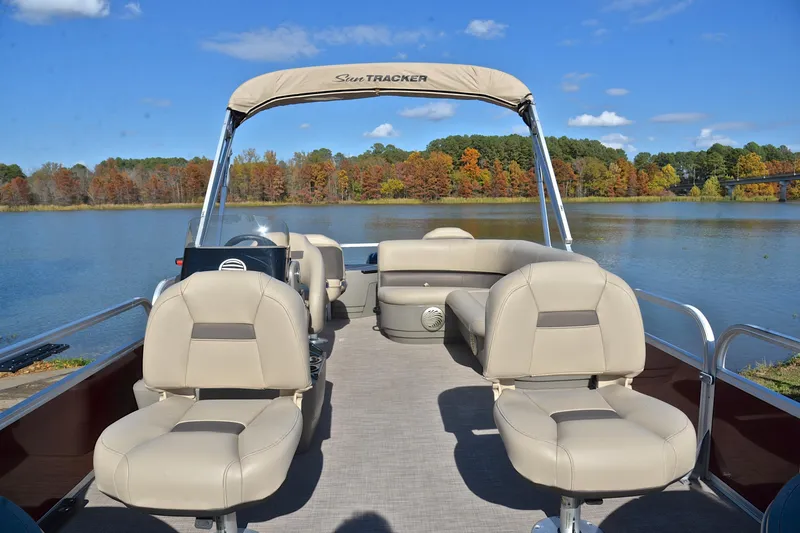 Slide: The Image of 2023 Sun Tracker Bass Buggy 18 DLX pontoon boat on a scenic lake. - 20