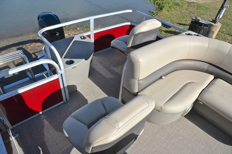 Slide: The Image of 2023 Sun Tracker Bass Buggy 18 DLX pontoon boat interior with beige seating and red accents. - 23