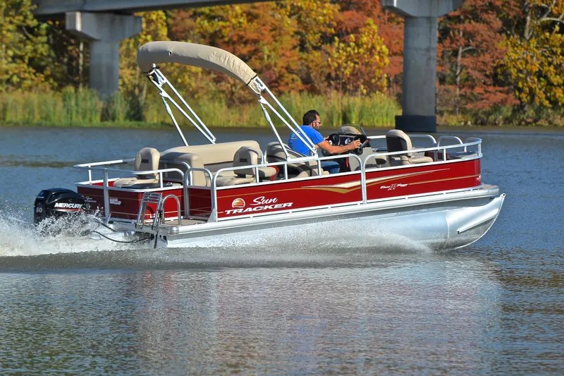 Slide: The Image of 2023 Sun Tracker Bass Buggy 18 DLX pontoon boat cruising on a lake. - 5