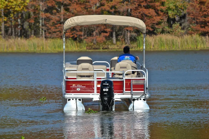 Slide: The Image of 2023 Sun Tracker Bass Buggy 18 DLX pontoon boat on a serene lake. - 7
