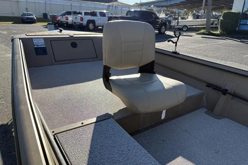 Slide: The Image of 2025 SeaArk DXS 1548 DKLD boat interior with beige seat in a parking lot. - 13