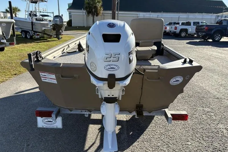 Slide: The Image of 2025 SeaArk DXS 1548 DKLD boat with outboard motor, parked on a trailer. - 2