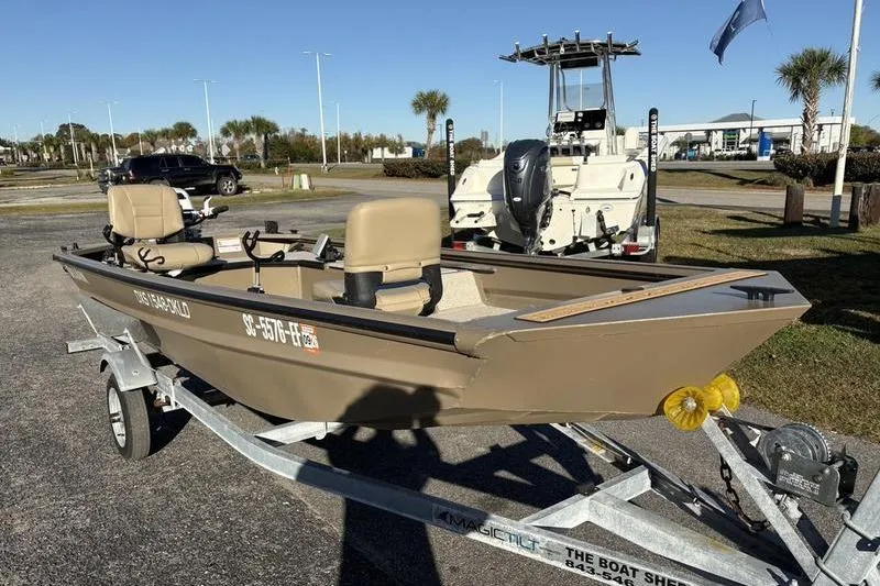 Slide: The Image of 2025 SeaArk DXS 1548 DKLD boat on trailer, parked outdoors in sunny setting. - 5