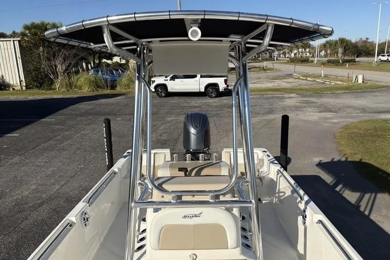Slide: The Image of 2026 Bulls Bay 2200 XS boat with T-top and outboard motor in a parking area. - 24