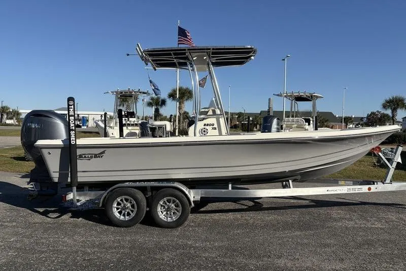 Slide: The Image of 2026 Bulls Bay 2200 XS boat on trailer, parked outdoors under clear sky. - 4