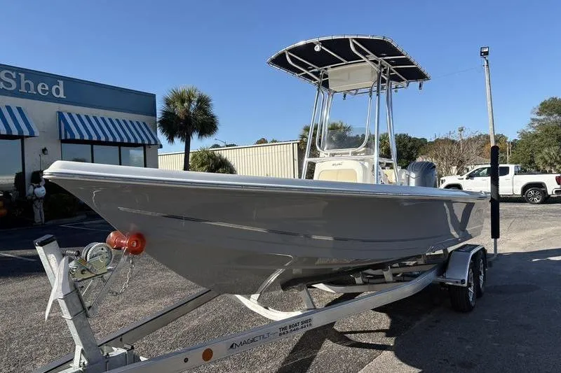 Slide: The Image of 2026 Bulls Bay 2200 XS boat on trailer, parked outside a building with palm trees. - 7
