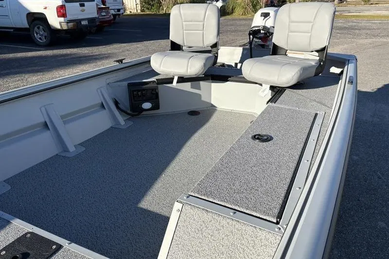 Slide: The Image of 2025 SeaArk DXS 1548 DKLD boat interior with two gray seats and storage compartments. - 12