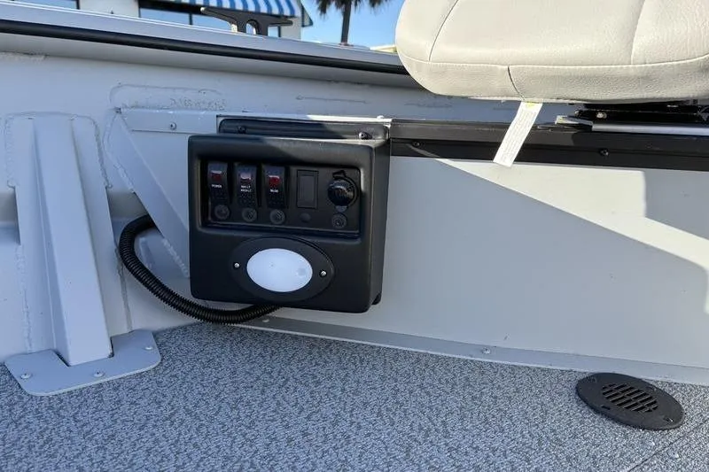 Slide: The Image of Control panel and seat in 2025 SeaArk DXS 1548 DKLD boat interior. - 14