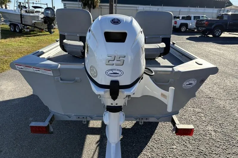 Slide: The Image of 2025 SeaArk DXS 1548 DKLD boat with a 25 HP outboard motor, parked outdoors. - 3