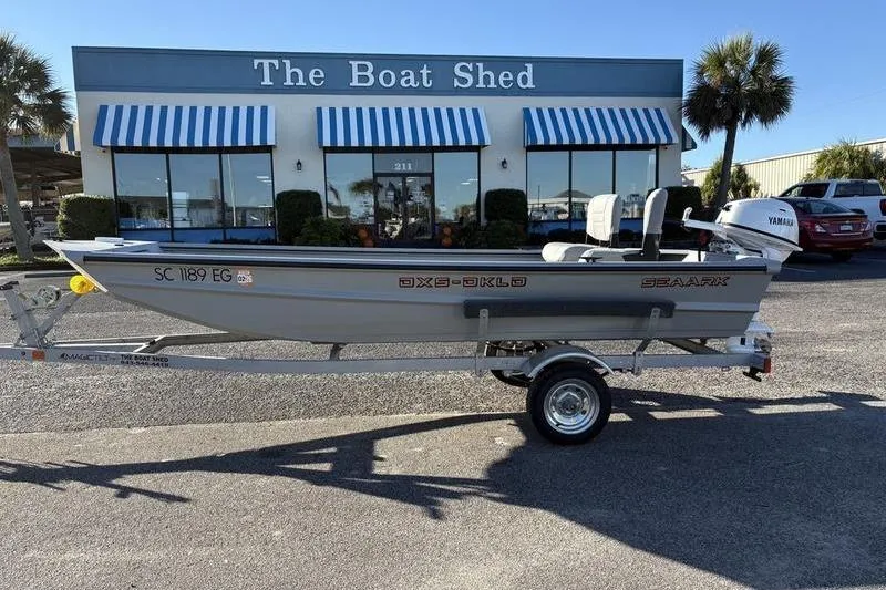 Slide: The Image of 2025 SeaArk DXS 1548 DKLD boat on trailer outside The Boat Shed. - 6
