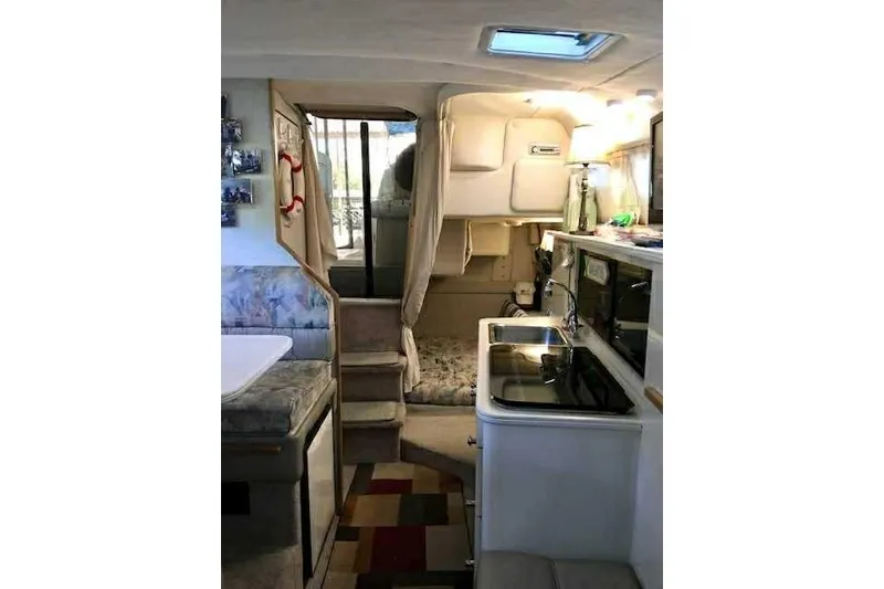 Slide: The Image of 1999 Bayliner 2855 Ciera interior with kitchenette, seating, and sleeping area. - 10