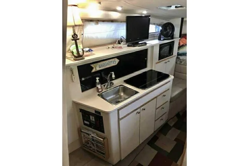 Slide: The Image of 1999 Bayliner 2855 Ciera boat interior with kitchenette, sink, and appliances. - 13