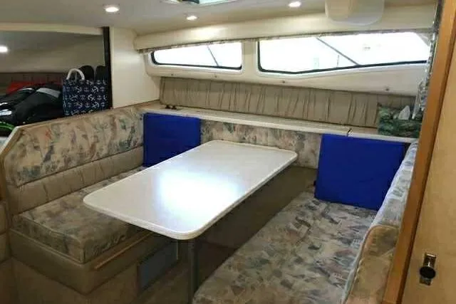 Slide: The Image of Interior of 1999 Bayliner 2855 Ciera with dining area and cushioned seating. - 3