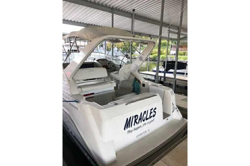 Slide: The Image of 1999 Bayliner 2855 Ciera boat docked, featuring open cockpit and canopy. - 4