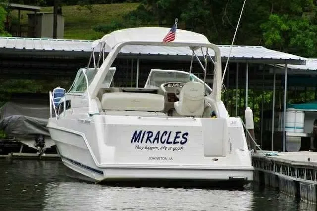 Slide: The Image of 1999 Bayliner 2855 Ciera boat named "Miracles" docked at a marina. - 8