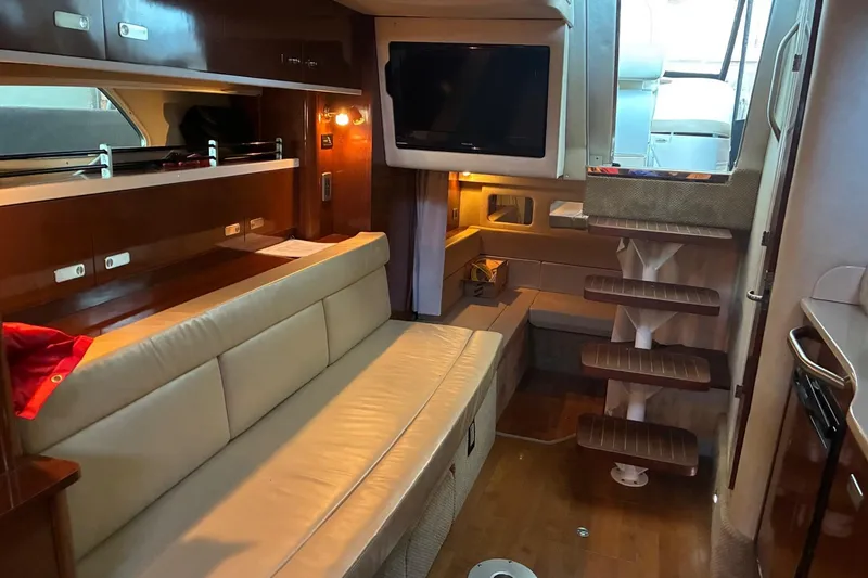 Slide: The Image of Interior of 2010 Sea Ray 350 Sundancer yacht with seating, TV, and wooden steps. - 17