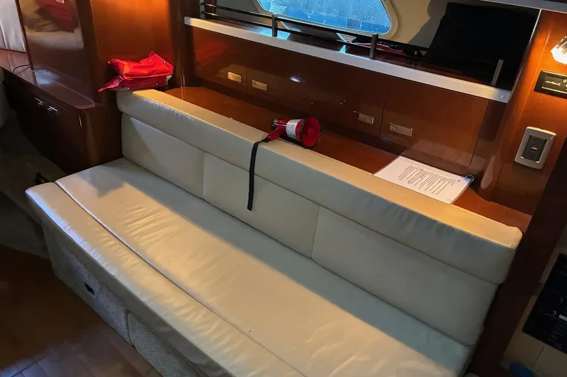 Slide: The Image of Interior of 2010 Sea Ray 350 Sundancer with cream leather seating and wooden cabinetry. - 18