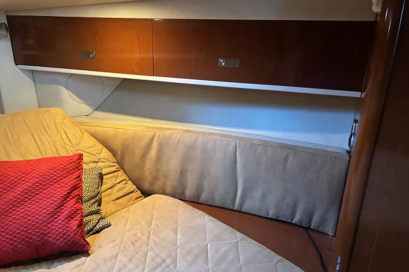 Slide: The Image of Interior cabin of 2010 Sea Ray 350 Sundancer with cushions and wooden storage cabinets. - 19