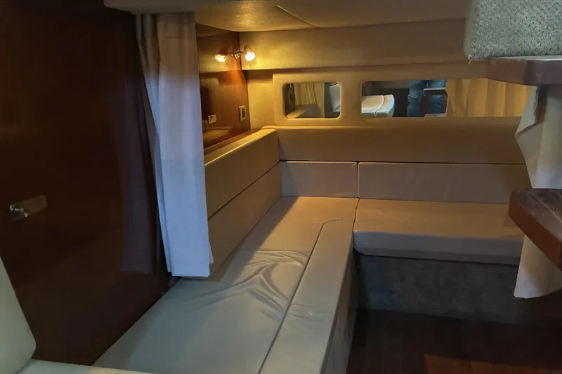 Slide: The Image of Interior of 2010 Sea Ray 350 Sundancer yacht with beige seating and wooden accents. - 22