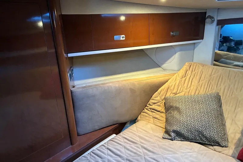 Slide: The Image of Interior cabin of 2010 Sea Ray 350 Sundancer with wooden cabinets and cozy bedding. - 24