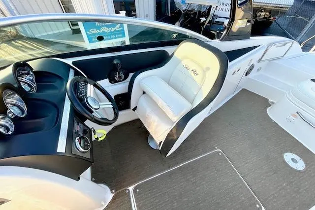 Slide: The Image of 2014 Sea Ray 260 Sundeck cockpit with steering wheel and comfortable seating. - 15