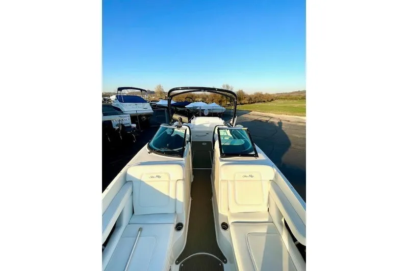 Slide: The Image of 2014 Sea Ray 260 Sundeck boat with open deck and seating, parked outdoors. - 25