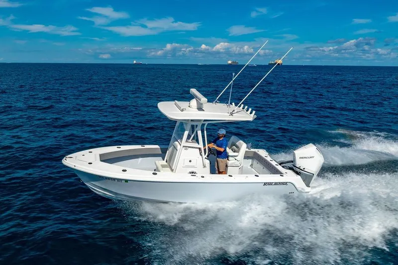 The Image of 2026 Reef Runner 230 boat cruising on open ocean under clear blue sky. - 19