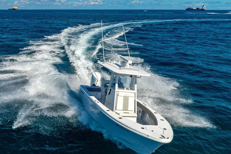 Slide: The Image of 2026 Reef Runner 230 boat cruising on open ocean with wake trails. - 22
