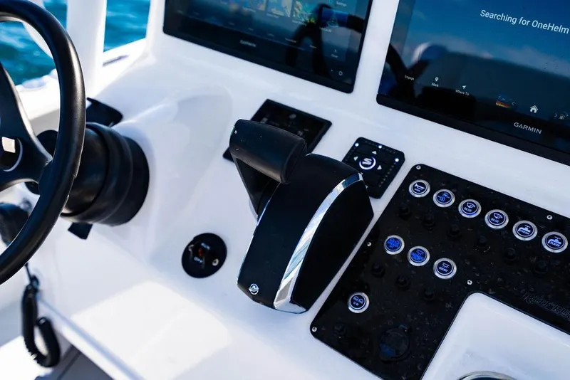 Slide: The Image of Control panel of 2026 Reef Runner 230 boat with steering wheel and digital displays. - 36