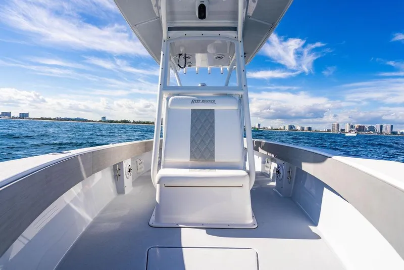 Slide: The Image of 2026 Reef Runner 230 boat on open water with city skyline in background. - 46