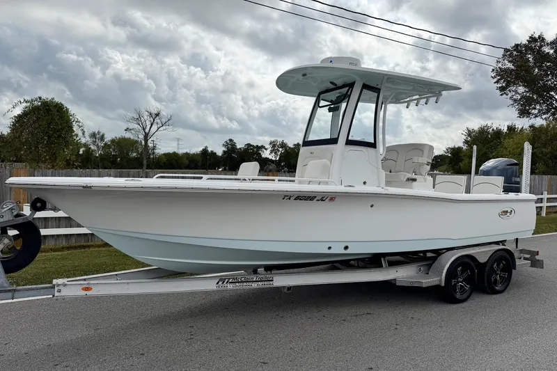 The Image of 2021 Sea Hunt BX 25 FS boat on trailer, parked on roadside under cloudy sky. - 1