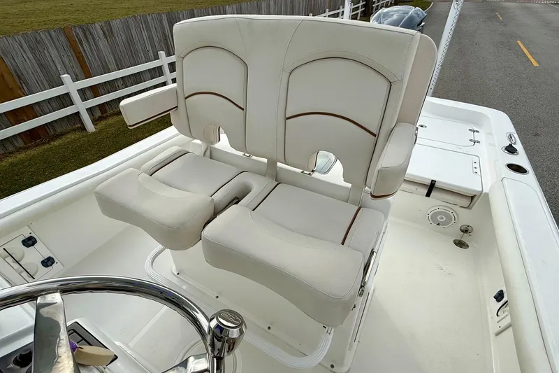 Slide: The Image of 2021 Sea Hunt BX 25 FS boat with dual white cushioned seats and steering wheel. - 10