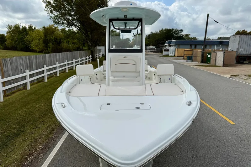 Slide: The Image of 2021 Sea Hunt BX 25 FS boat on a road, showcasing sleek design and spacious seating. - 6