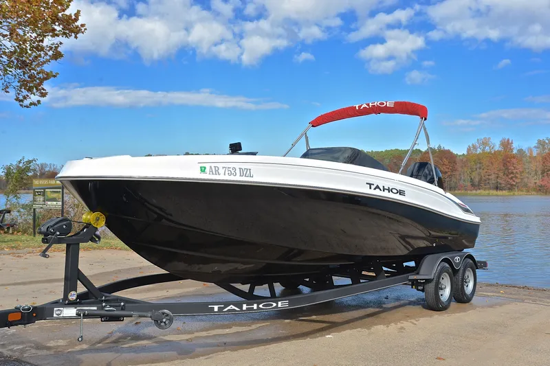 Slide: The Image of 2024 Tahoe T21 boat on trailer by a scenic lake under blue sky. - 10