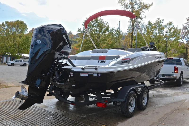 Slide: The Image of 2024 Tahoe T21 boat on trailer with Mercury outboard motor, parked outdoors. - 14