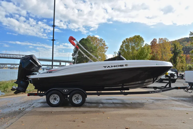 Slide: The Image of 2024 Tahoe T21 boat on trailer by riverside with autumn trees in background. - 15
