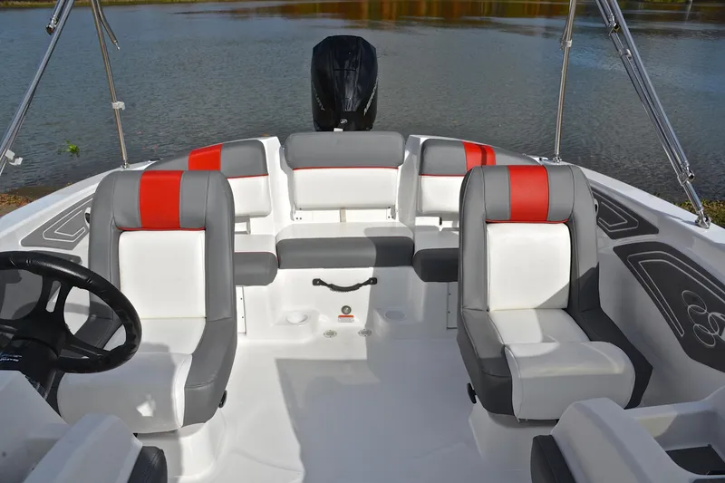 Slide: The Image of 2024 Tahoe T21 boat interior with red and gray seating, steering wheel, and water backdrop. - 22