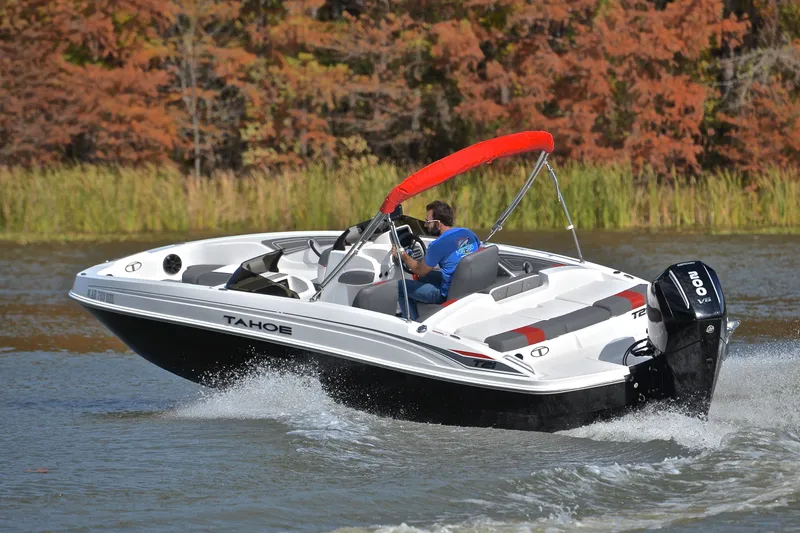 Slide: The Image of 2024 Tahoe T21 boat cruising on a lake with autumn foliage in the background. - 6