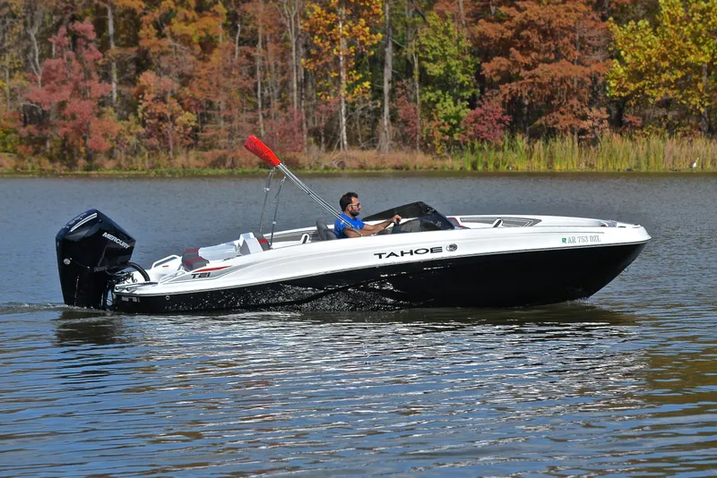 Slide: The Image of 2024 Tahoe T21 boat cruising on a lake with autumn foliage in the background. - 7
