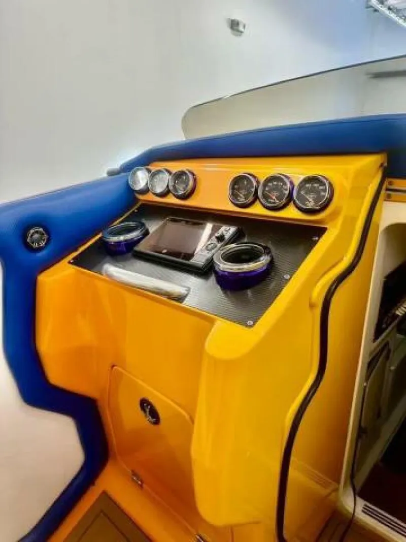 Slide: The Image of 2005 Cigarette 39 Top Gun boat dashboard with vibrant yellow and blue design, featuring gauges and controls. - 18