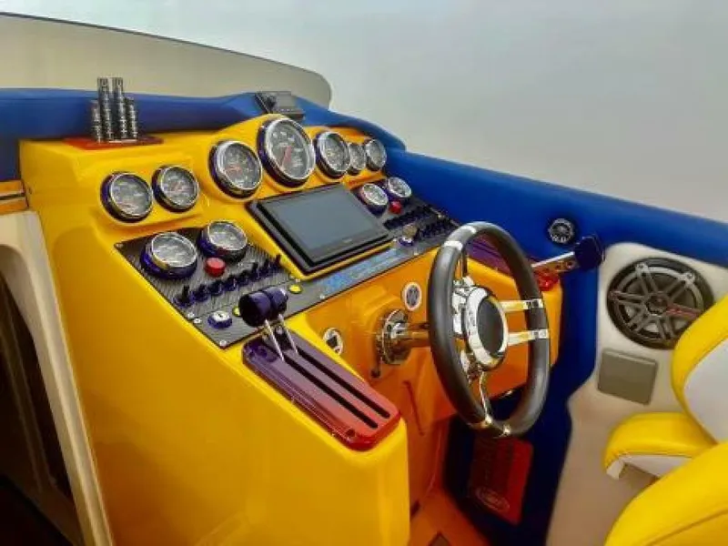 Slide: The Image of 2005 Cigarette 39 Top Gun boat dashboard with vibrant yellow and blue design, featuring gauges and controls. - 19